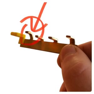 Bent copper busbar terminal modified to fit a consumer unit device, marked with a red arrow.
