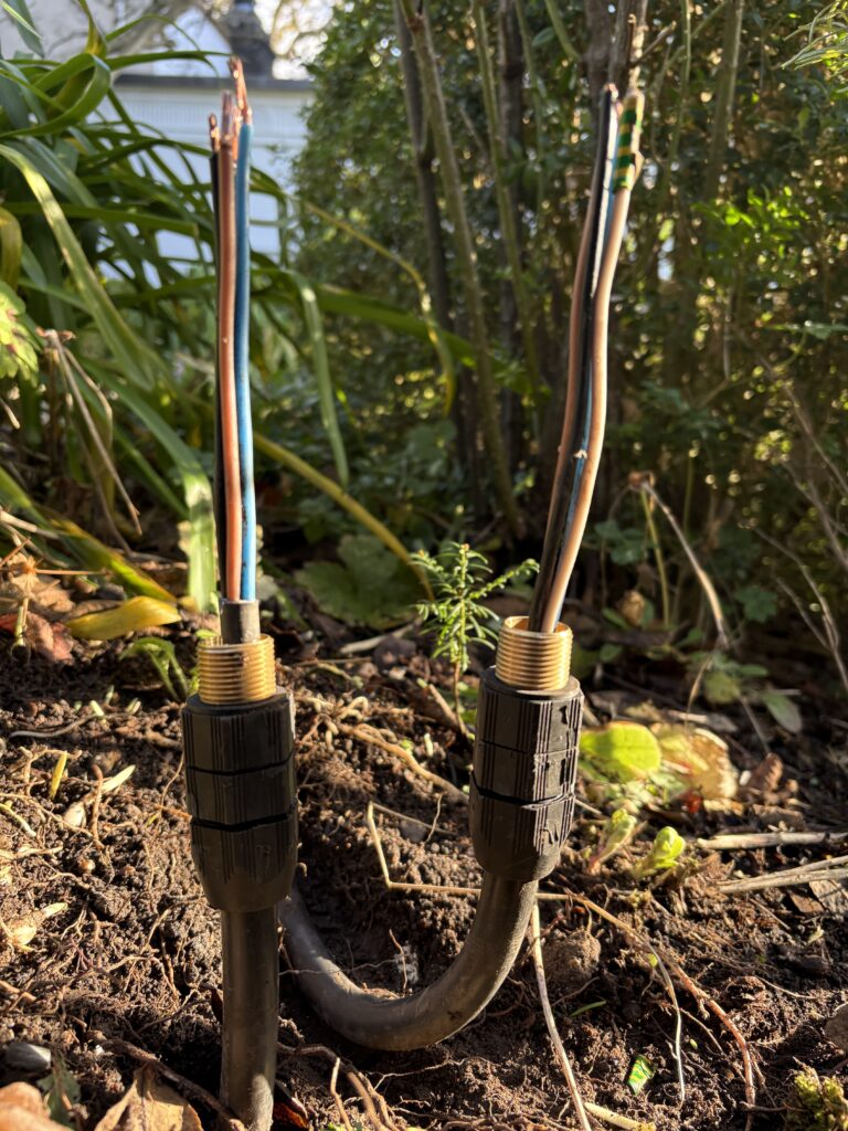 Wiring Garden Lights: Complete Installation Guide for Outdoor Lighting 3 Two steel wire armoured (SWA) cables fitted with outdoor storm glands, showing the cable termination with waterproof glands that provide mechanical protection, strain relief, and sealing against moisture for outdoor electrical installations