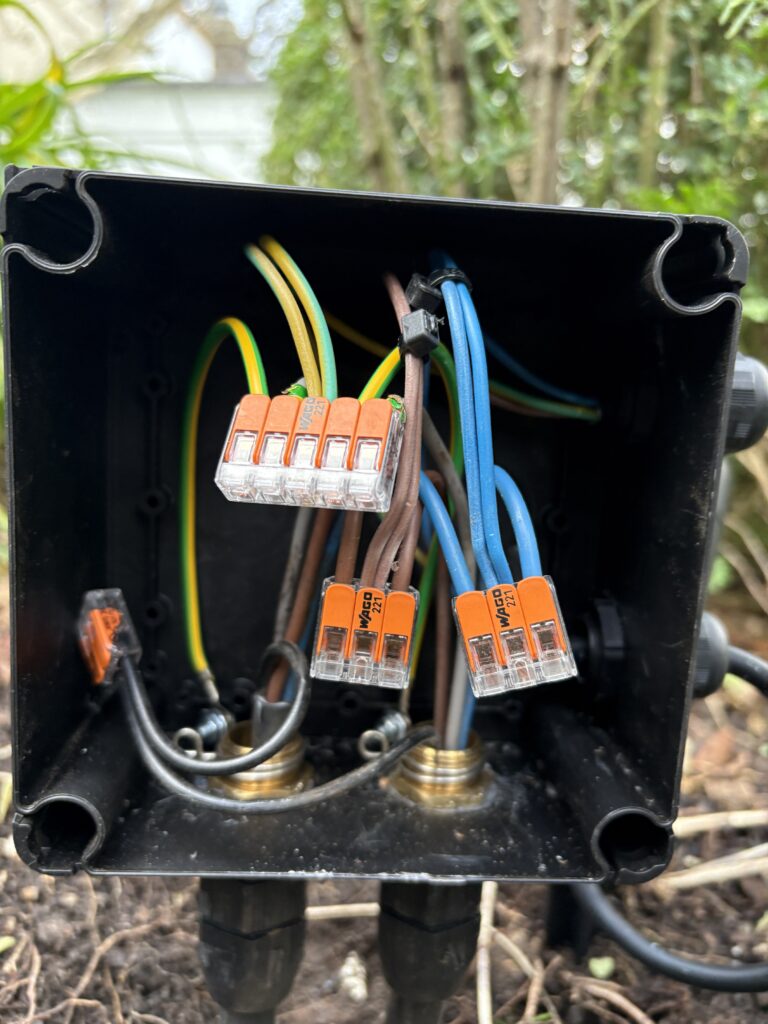 Wiring Garden Lights: Complete Installation Guide for Outdoor Lighting 2 Weatherproof WISKA junction box used in an outdoor electrical installation, containing WAGO lever connectors and SWA cable glands fitted with WISKA spring inserts to ensure secure cable termination and proper earthing of steel wire armoured cables inside an IP-rated enclosure suitable for garden lighting circuits.